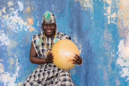 Handsome African man with traditional clothes and musical instrumentsの写真素材