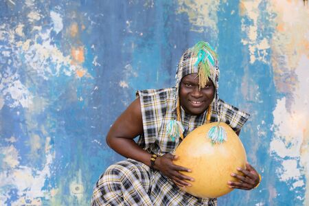 Handsome African man with traditional clothes and musical instruments
