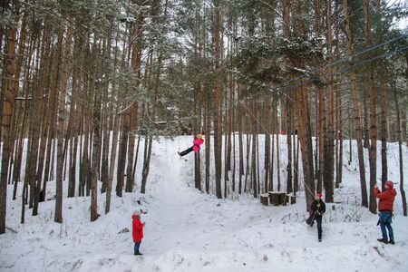 Russia, Izhevsk - January 7, 2020: Riding on rope trolley Track in winter. People having fun together. Extreme and active lifestyle.のeditorial素材
