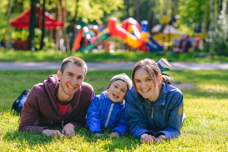 Happy family together in outdoor park at spring sunny day. Mom, dad and son in the garden. Group of...