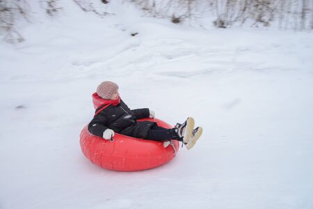 Russia, Izhevsk - January 7, 2020: People sliding down on snow tubes. Winter, leisure and sportのeditorial素材