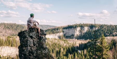 Young hiker sitting and relaxing on top of a mountainの写真素材