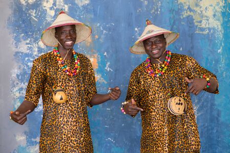 Handsome african men in traditional Fulani hats and colorful clothes smiling and looking at camera.の写真素材