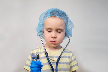 Small boy playing doctor wearing a stethoscopeの写真素材