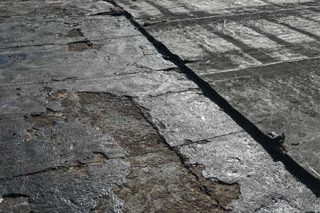 Bitumen flat roofing renovation, background texture of removed damaged insulation layer of roof.