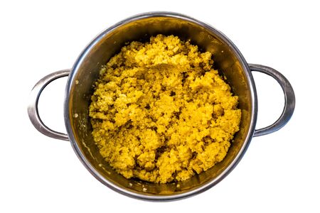 cooked steamed orange quinoa grits in a pan isolated on white backgroundの写真素材