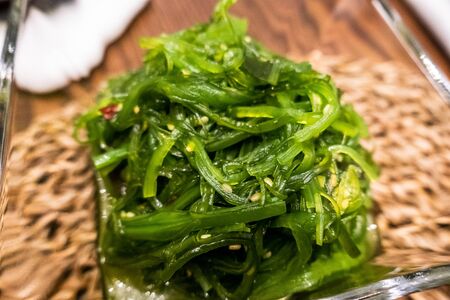 Healthy wakame seaweed salad on wooden board. Top view.