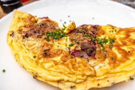 Breakfast food - Omelette with meat, cheese, onion on the white plate