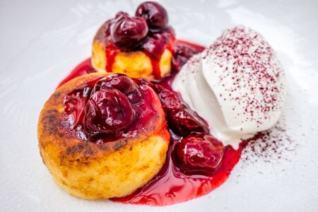 cottage cheese pancakes with sour cream on white platesの写真素材