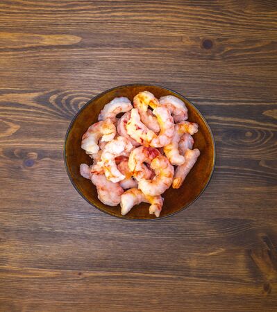 plate of fresh frozen shrimp on a wooden tableの写真素材