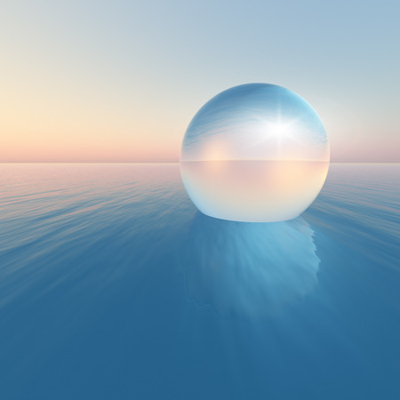 A surreal crystal sphere floating over the ocean horizon on clear morning sky.の写真素材