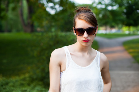 Girl shows emotion in a park during summer.の写真素材