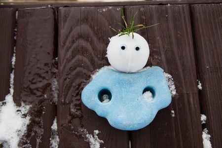 The snowball-sized snowman that looks like a snowgirl or snowangel and is on  wood fence.の写真素材