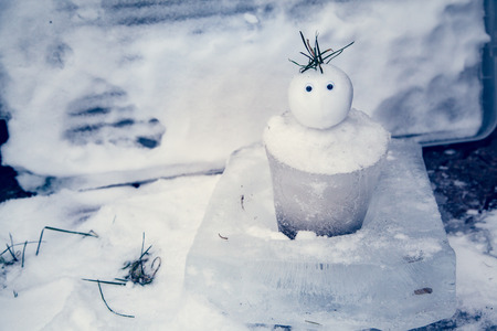 Small snowman made of ice in Winter after fresh snowfall and has an ice bucket-shaped body.の写真素材