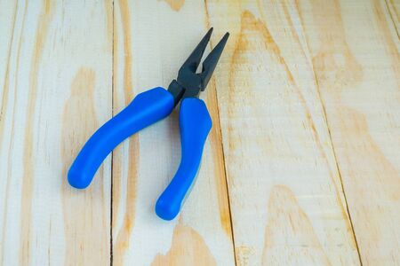 Blue pliers on woodenの写真素材