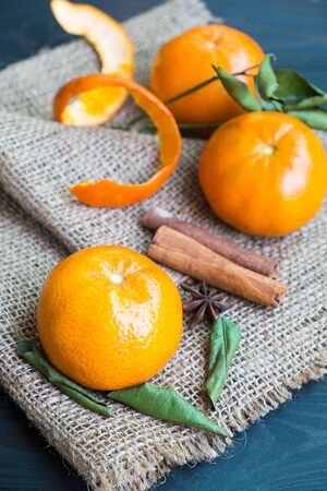 Fresh orange and leaf on hemp sack,  group of mandarin orange on black woodenの写真素材