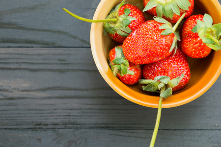 Fresh Strawberries in bow on black woodenの写真素材