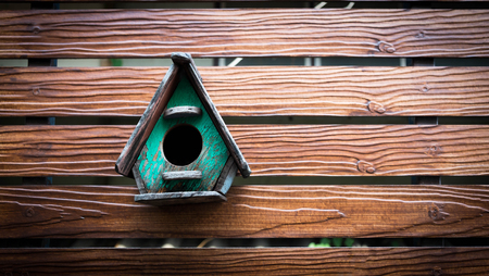 cute little birdhouse on wooden fenceの写真素材