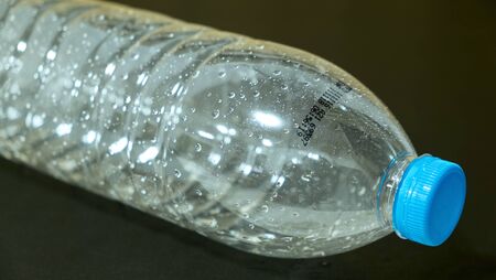 manufacturing date and expiration date on transparent bottle , drop of water in bottle