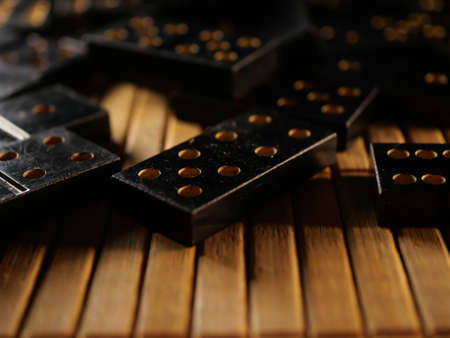 Black vintage dominoes on a black background, selective focus. WB photo.の写真素材