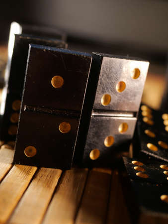 Black vintage dominoes on a black background, selective focus. WB photo.の写真素材