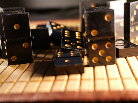 Black vintage dominoes on a black background, selective focus. WB photo.