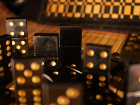 Black vintage dominoes on a black background, selective focus. WB photo.の写真素材