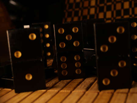 Black vintage dominoes on a black background, selective focus. WB photo.の写真素材
