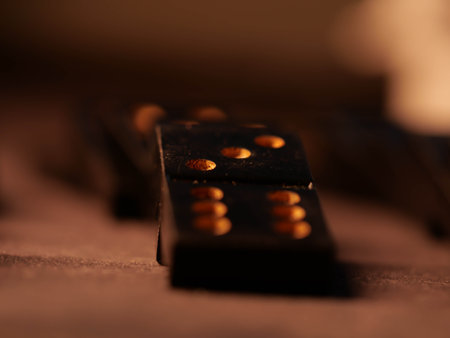 Black vintage dominoes on a black background, selective focus. WB photo.