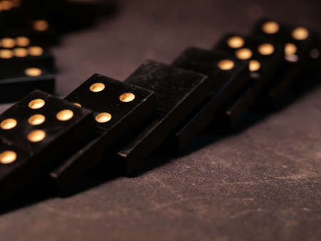 Black vintage dominoes on a black background, selective focus. WB photo.