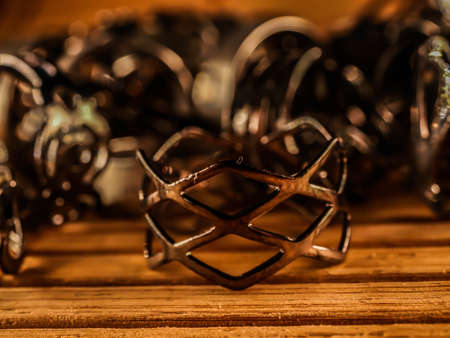 A lot of costume jewelry, jewelry made of gold and silver, lie on a wooden surface. Women's day,...