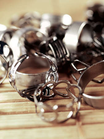 A lot of costume jewelry, jewelry made of gold and silver, lie on a wooden surface. Women's day,...