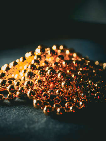 Pearls. Gold silver pearl beads on a dark background, on a dark table