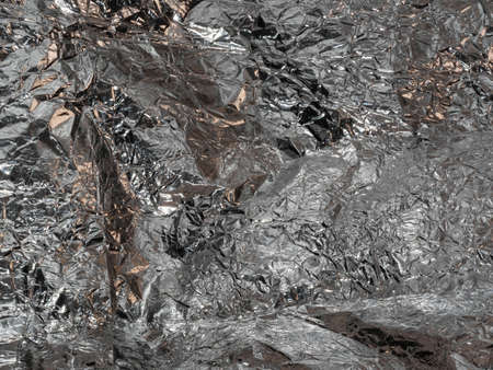 Thin sheet of silver leaf background with shiny uneven surface
