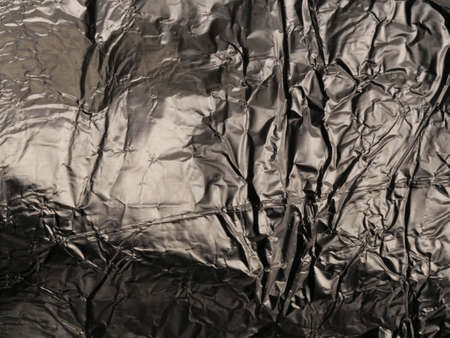 Thin sheet of silver leaf background with shiny uneven surface