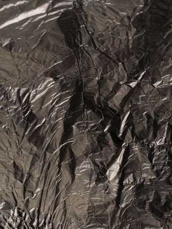 Thin sheet of silver leaf background with shiny uneven surface