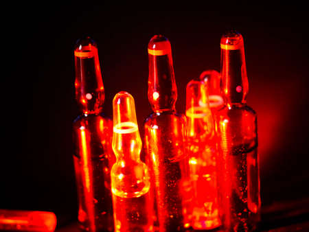 Medical ampoules close up. Many ampoules. Glass ampoules on the table. Scattered ampoules with medicine.の写真素材