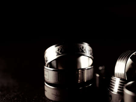 A lot of costume jewelry, jewelry made of gold and silver, lie on a black surface. Women's day, stylish image, accessories. Wardrobe addition, style, metalの写真素材