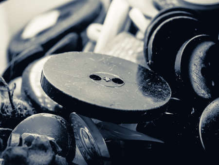 Grayscale photo of buttons. Collection of assorted spare clothes buttons. Macro. DOF