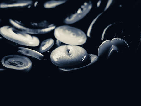 Grayscale photo of buttons. Collection of assorted spare clothes buttons. Macro. DOFの写真素材