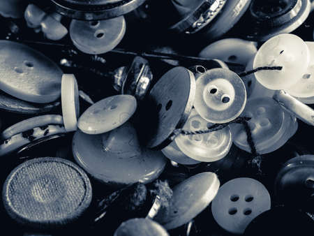 Grayscale photo of buttons. Collection of assorted spare clothes buttons. Macro. DOFの写真素材