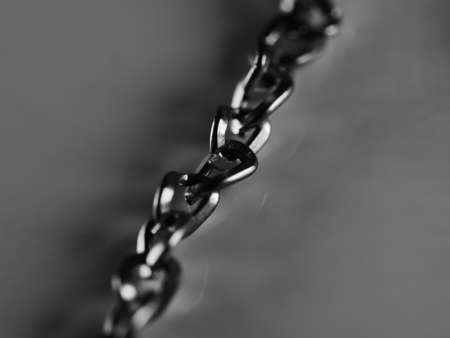 Necklace chain on white background, selective focus, macro