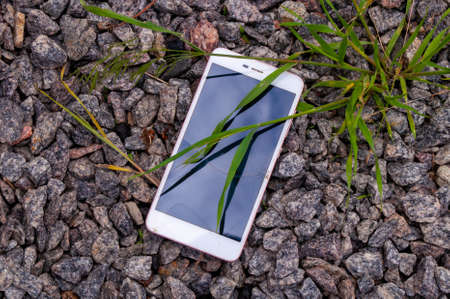 Smartphone with a broken screen. Broken phone on the stones. stock photo