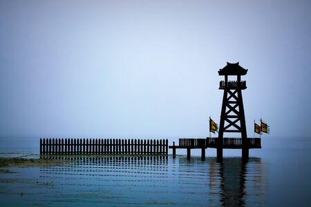 Chinese watchtower on a misty lakeの写真素材