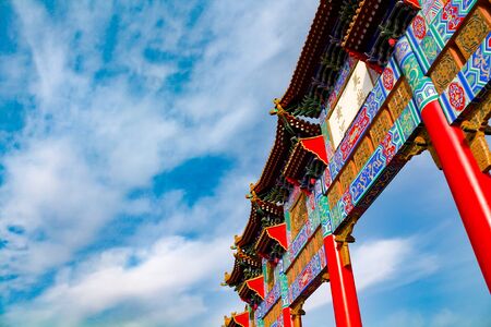 A Chinese paifang gate with blue sky in the backgroundのeditorial素材