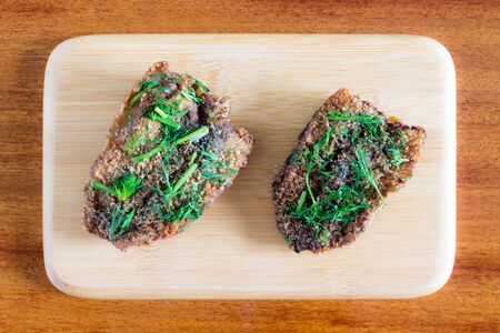 Two pieces of Herring steak on wooden serving boardの写真素材