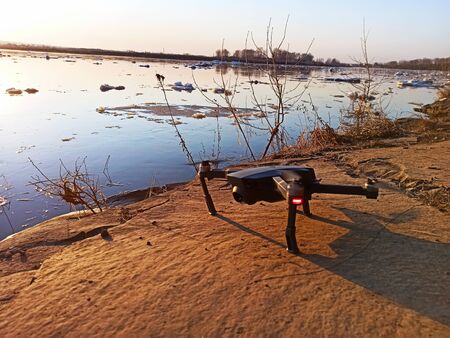 quadcopter flies over the river at sunset