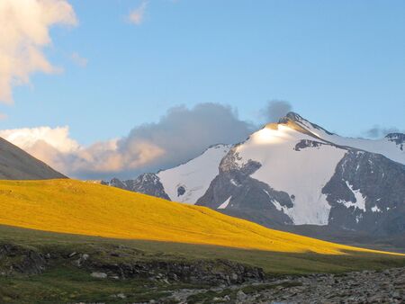 Landscape of snowy mountain peaks in the clouds. The concept of global warming and glacier melting.の写真素材