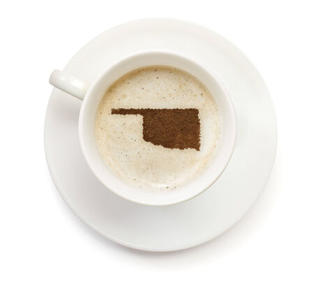 A cup of coffee with foam and powder in the shape of Oklahoma.(series)の写真素材