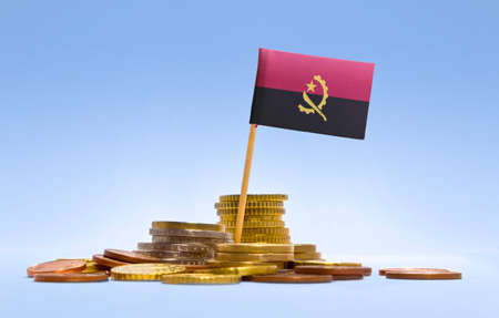 Flag of Angola in a mixed stack of european coins and a blue background.(series)の写真素材